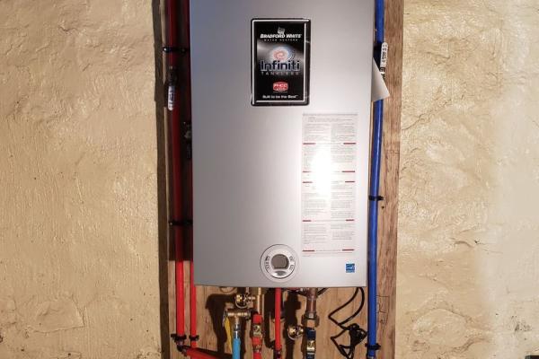 A modern tankless water heater installed in the basement of a home in Nazareth, PA, by Applause Plumbing, providing endless hot water on demand and saving energy.