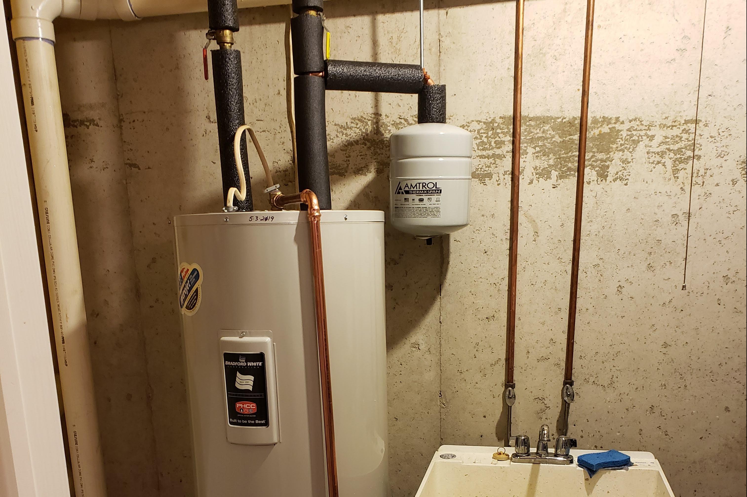 New water heater in a basement of Easton, PA. Expertly installed by Applause Plumbing and Heating. Enhanced insulation with extra foam around pipes for increased energy efficiency and optimal performance.