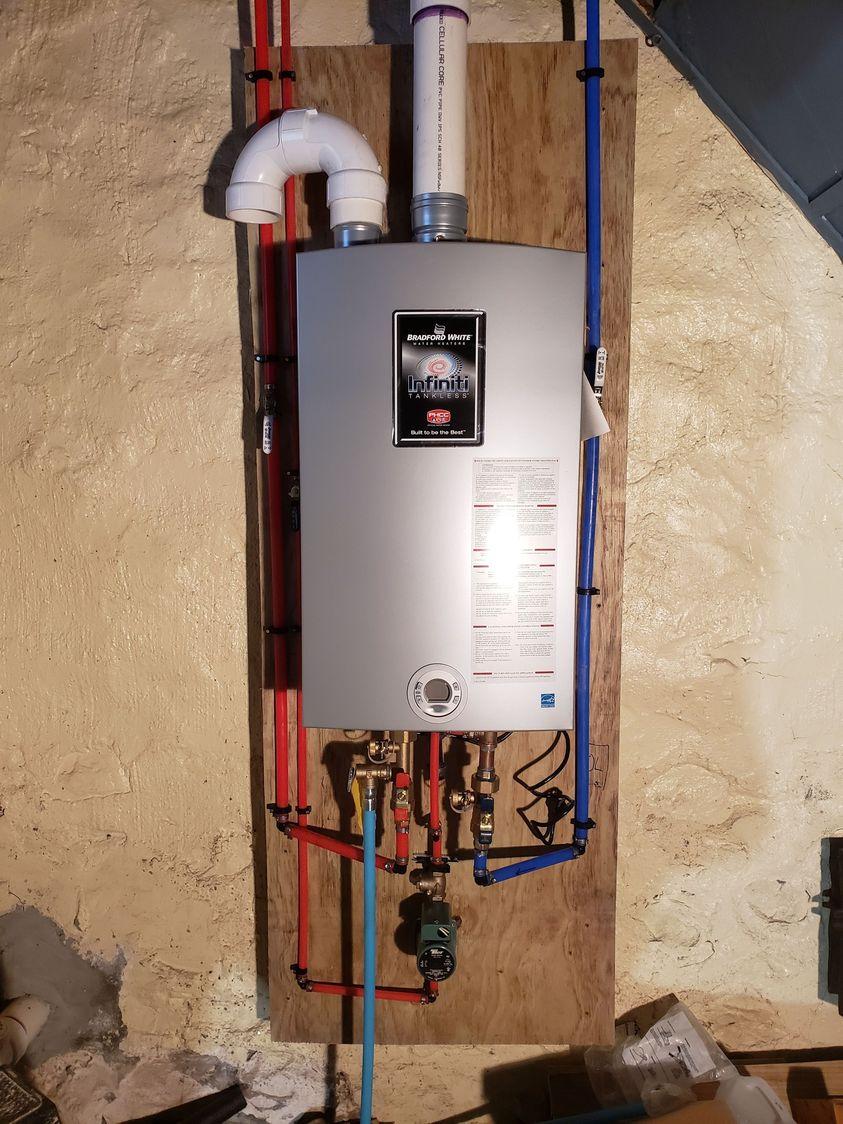 A modern tankless water heater installed in the basement of a home in Nazareth, PA, by Applause Plumbing, providing endless hot water on demand and saving energy.